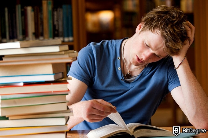 Introduction to programming using Python: a man reading a book on Python looking unhappy.